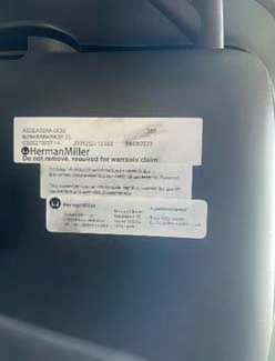 Manufacturing label under the seat of a Herman Miller chair Manufacturing label under the seat of a Herman Miller chair showing the model number, order number and manufacture date